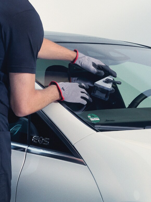 A woman raises her hand in front of the air conditioning vents in her Mercedes-Benz.