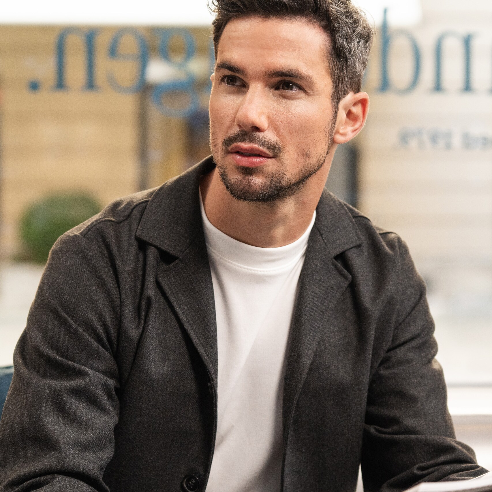 A person sitting on a sofa reading a Mercedes-Benz brochure. 