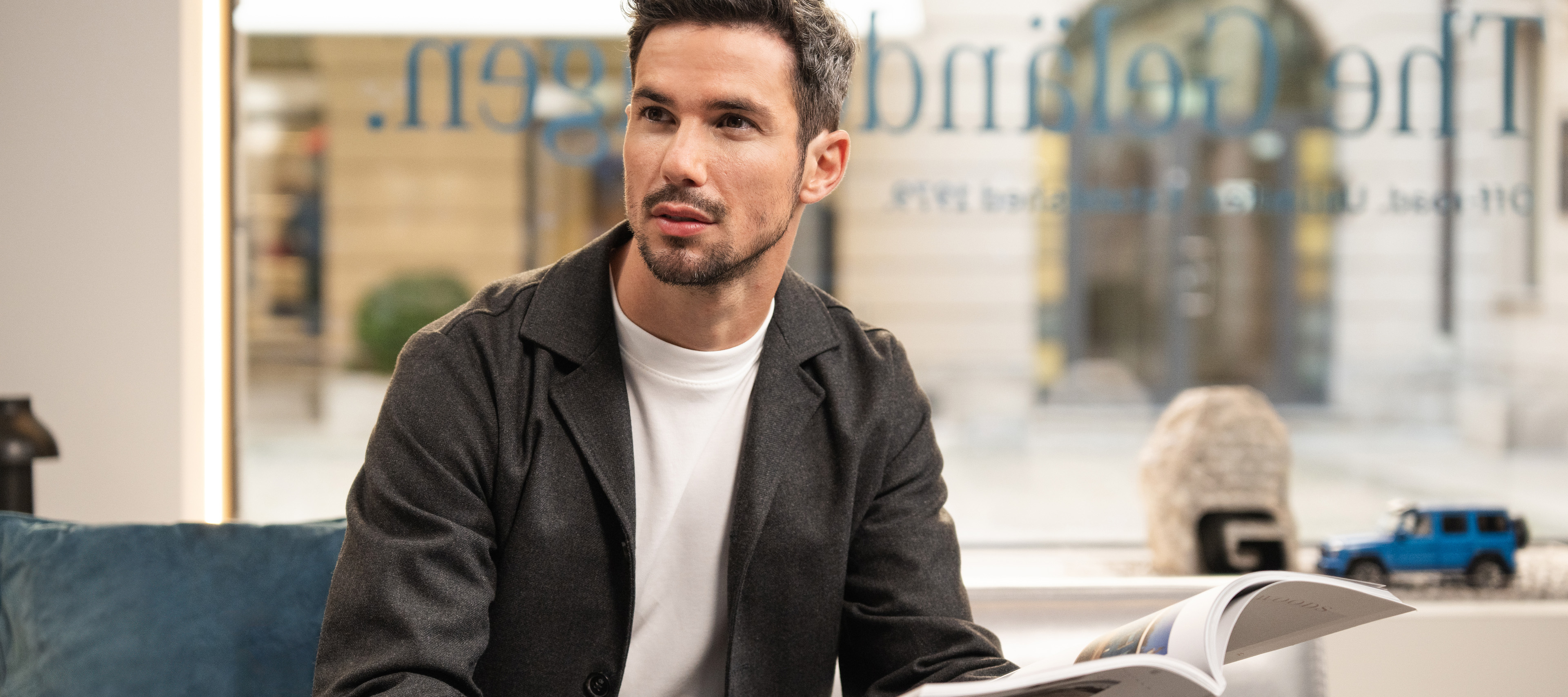 Finance Lease A person sitting on a sofa reading a Mercedes-Benz brochure.