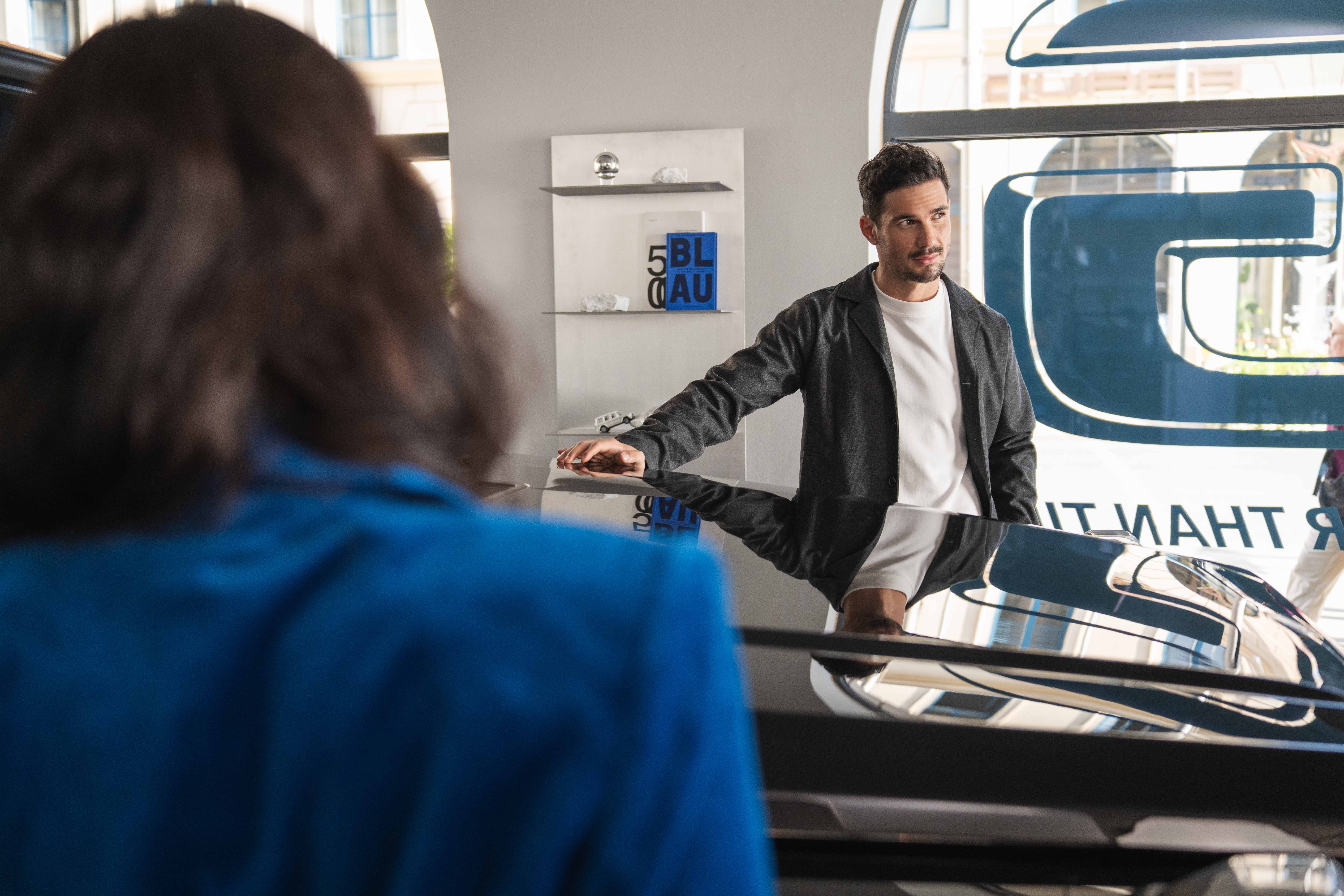ServiceCare Two people smiling and talking in front of a Mercedes-Benz vehicle.