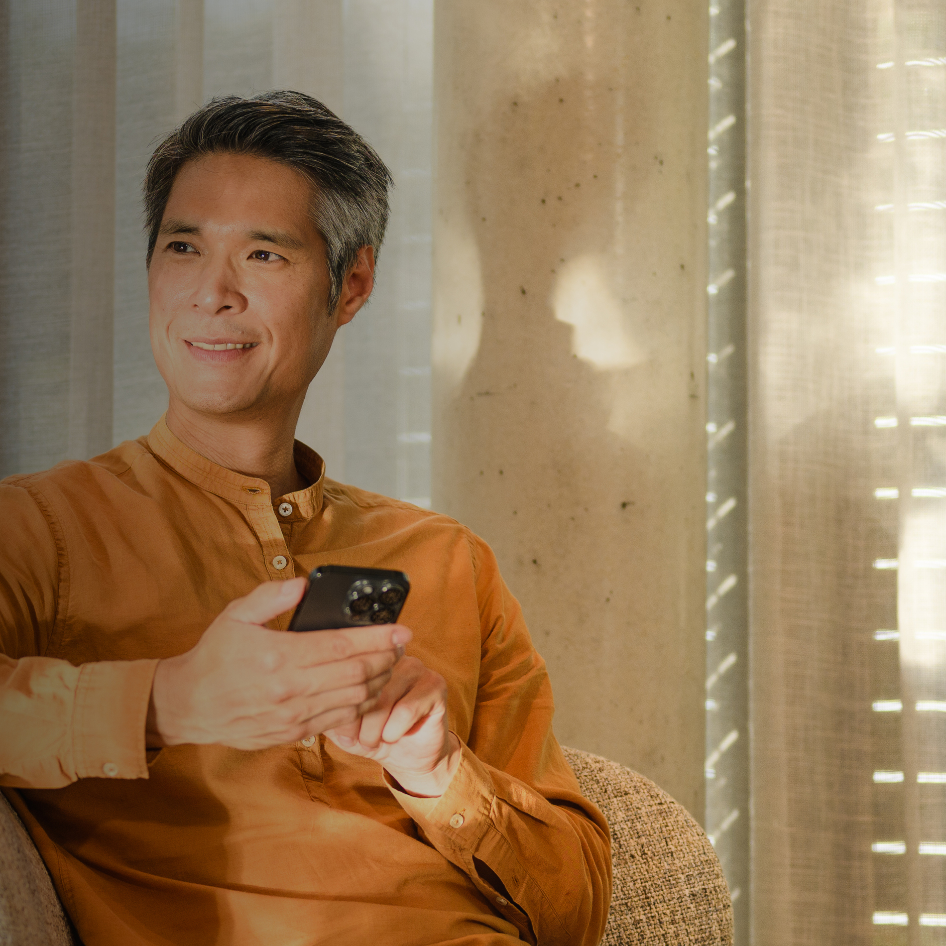 Man on a sofa using his phone to fill in a form Man on a sofa using his phone to fill in a form.