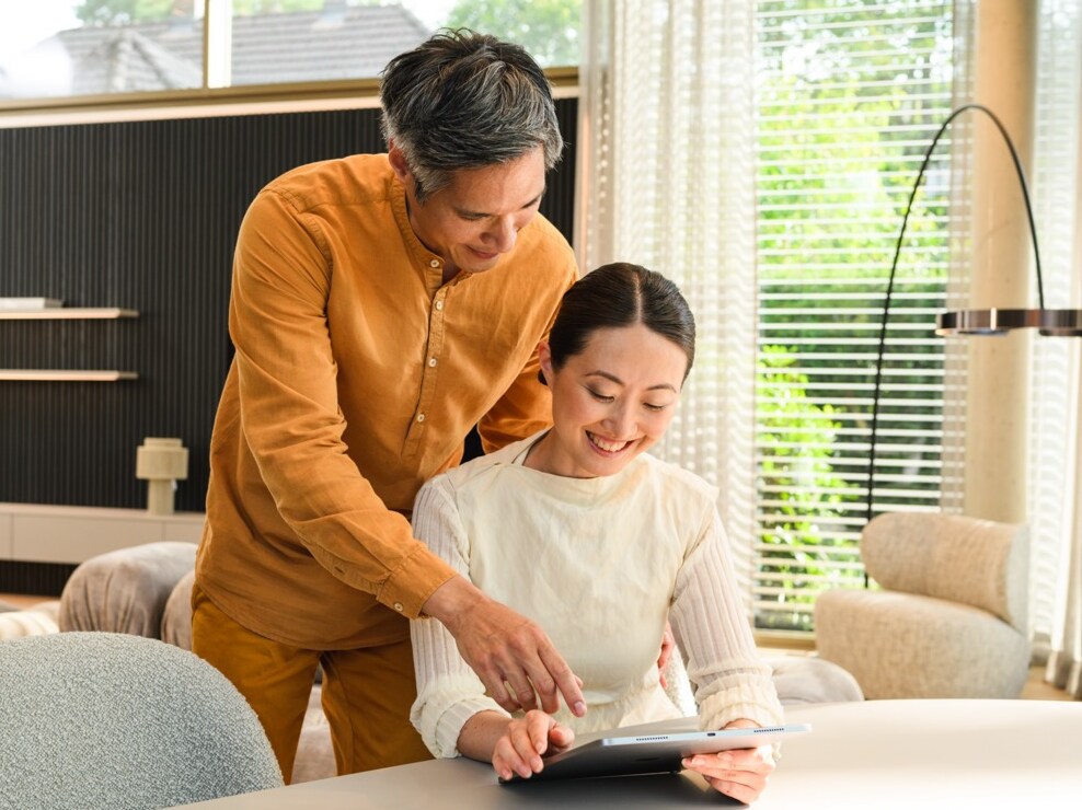 Two people using a tablet together in a modern home setting  