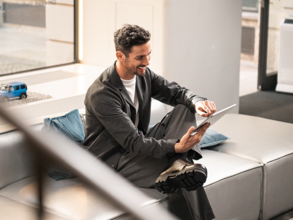 Person using a tablet while seated in a modern lounge area.  