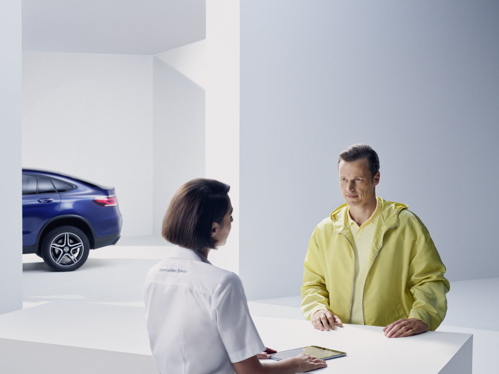 A woman, standing in front of her Mercedes and looking in a good mood.