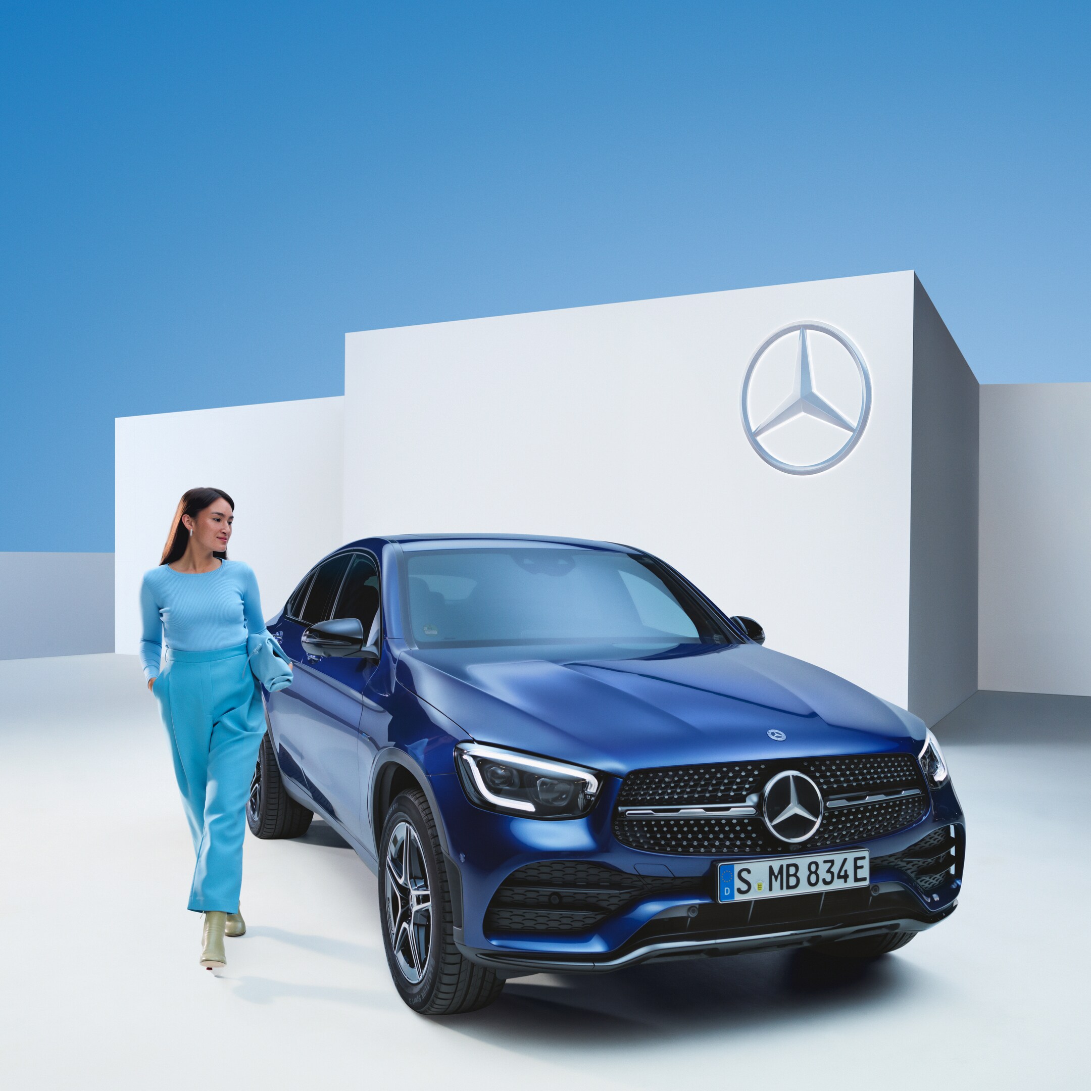 A relaxed woman at the wheel of her Mercedes.