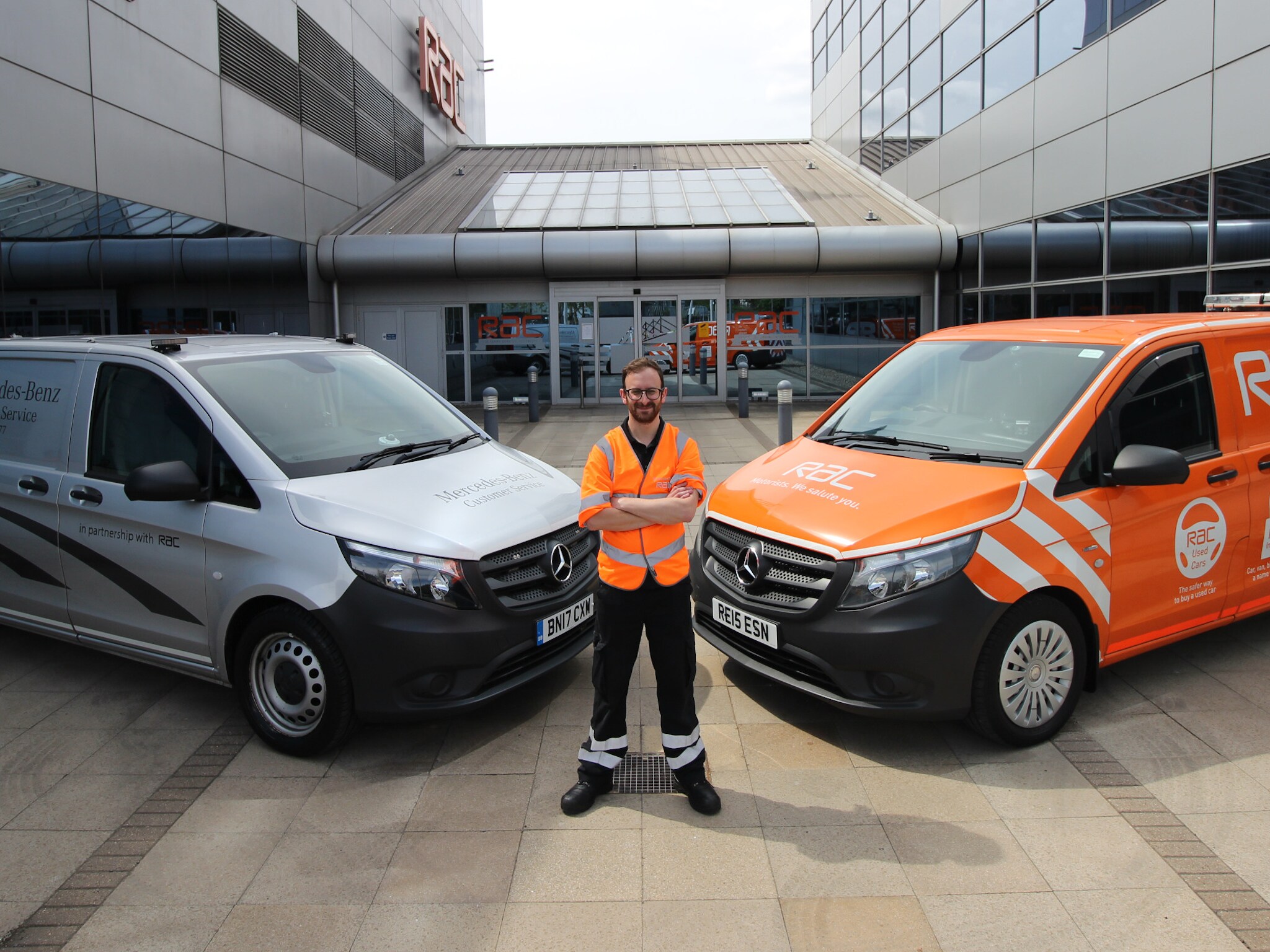 RAC Roadside assistance staff member standing in front of two RAC vans