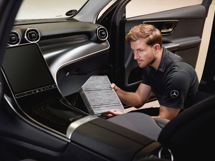 A woman raises her hand in front of the air conditioning vents in her Mercedes-Benz.