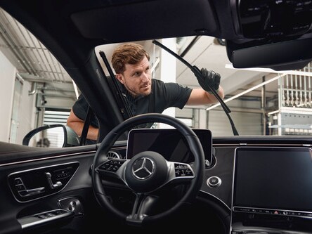 A Mercedes-Benz technician changes the windscreen wipers on the vehicle.