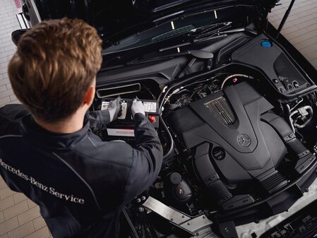A Mercedes-Benz technician checks the vehicle's electrical system battery.