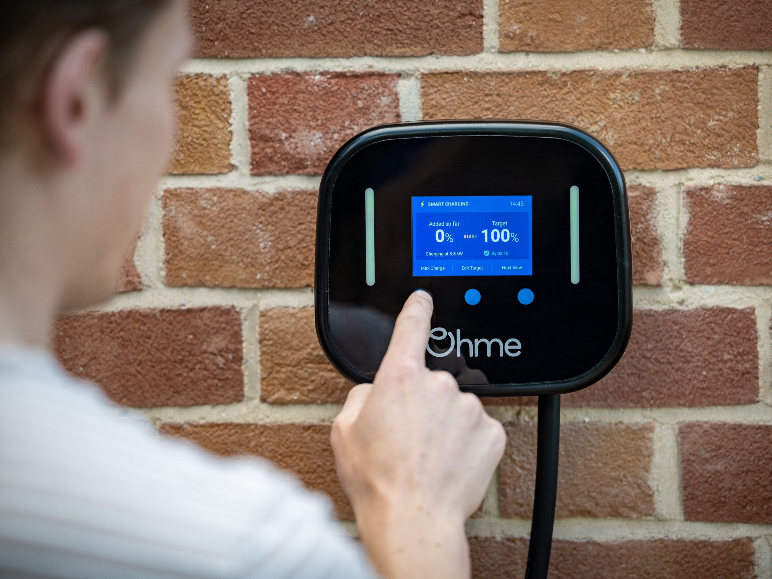 Ohme EV charging box on brick wall