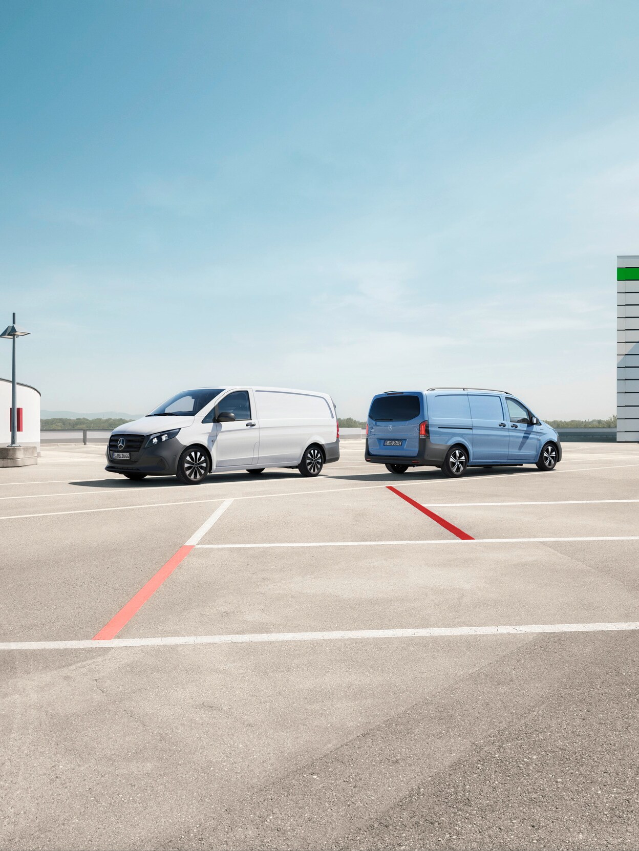 Three Mercedes-Benz Vito vans (grey, blue, white) parked outdoors with a modern building and blue sky in the background.