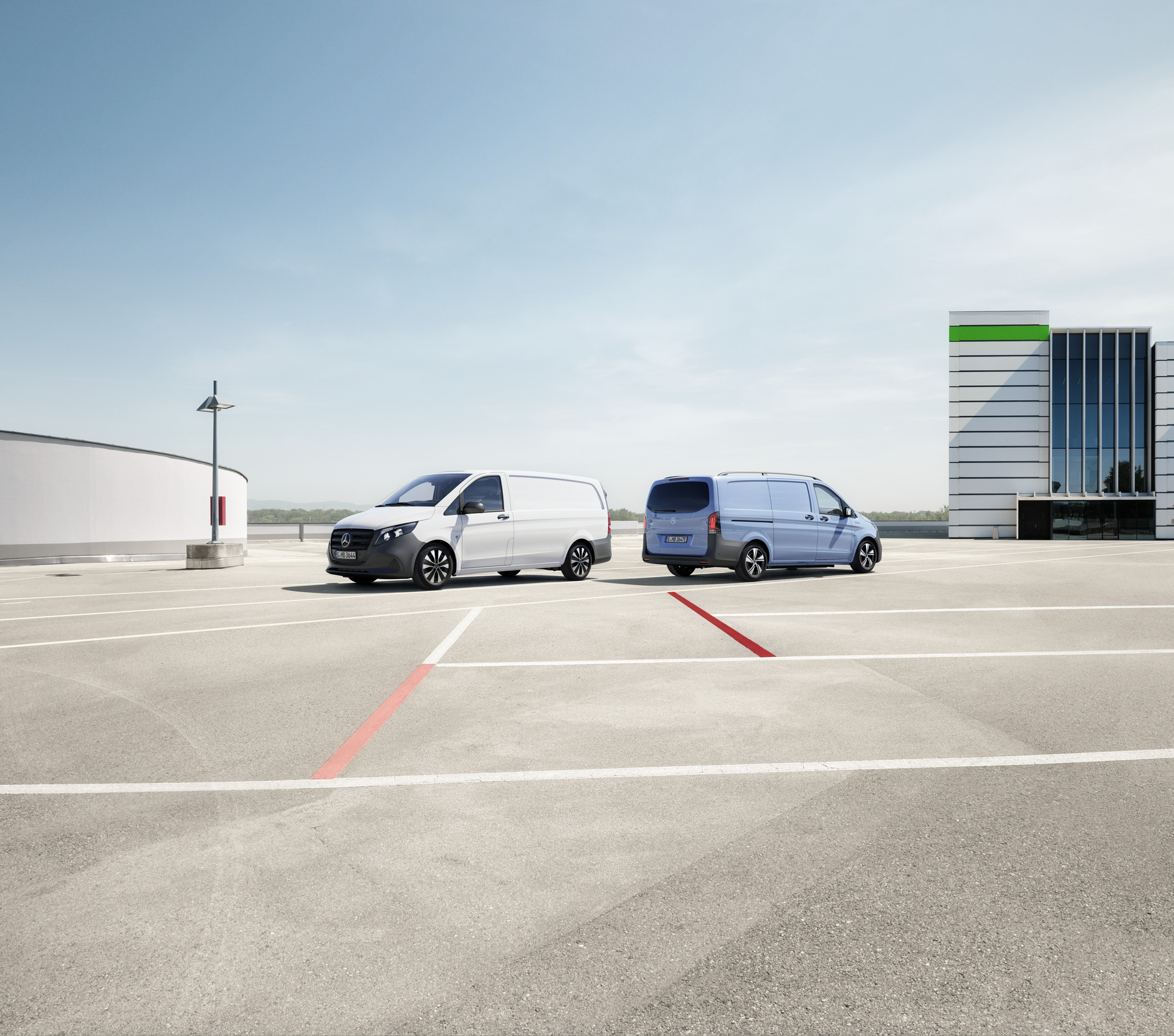 Vito | Mercedes-Benz vans Three Mercedes-Benz Vito vans (grey, blue, white) parked outdoors with a modern building and blue sky in the background.