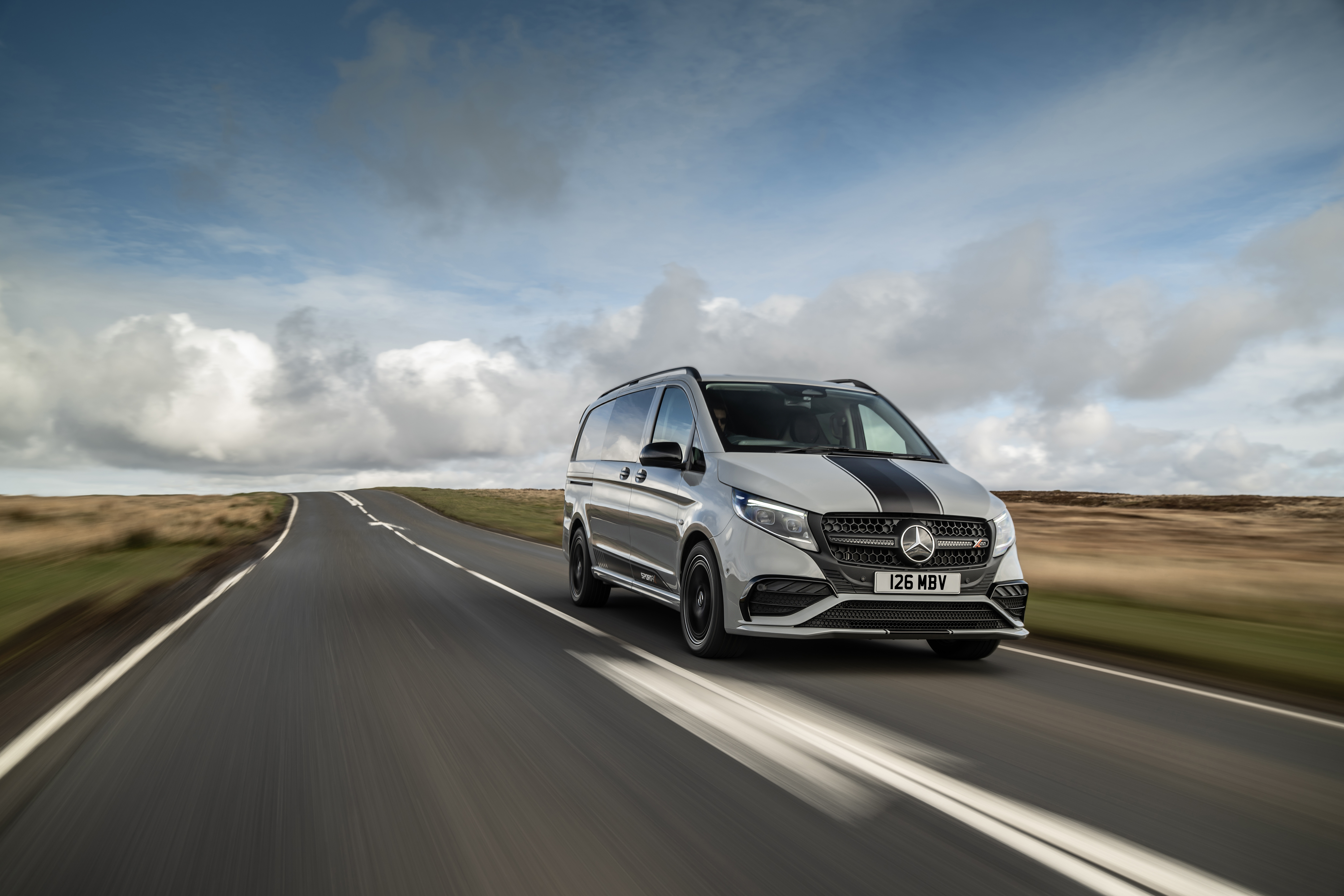 White Mercedes-Benz Vito Panel Van parked by modern concrete structure.