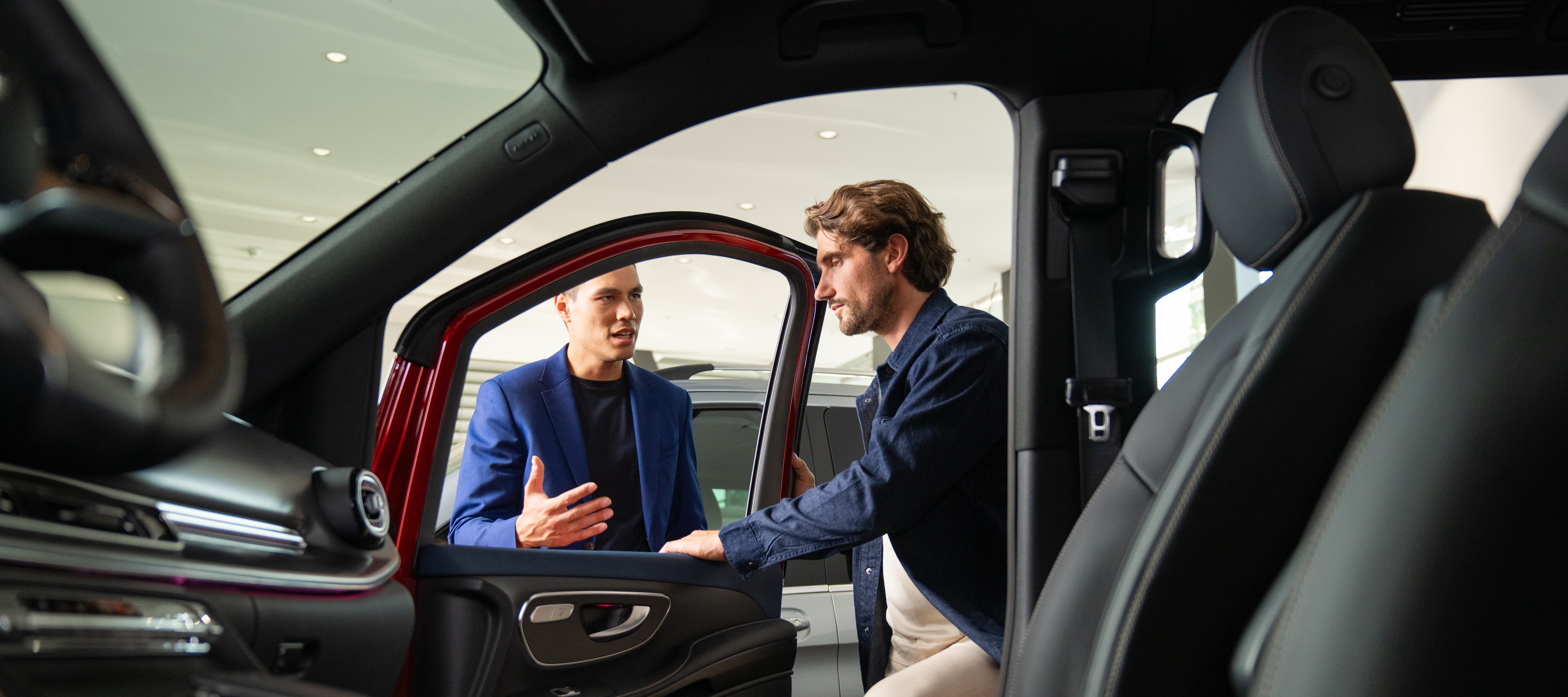 Hire Purchase Two people opening a Mercedes-Benz Van door and looking inside.