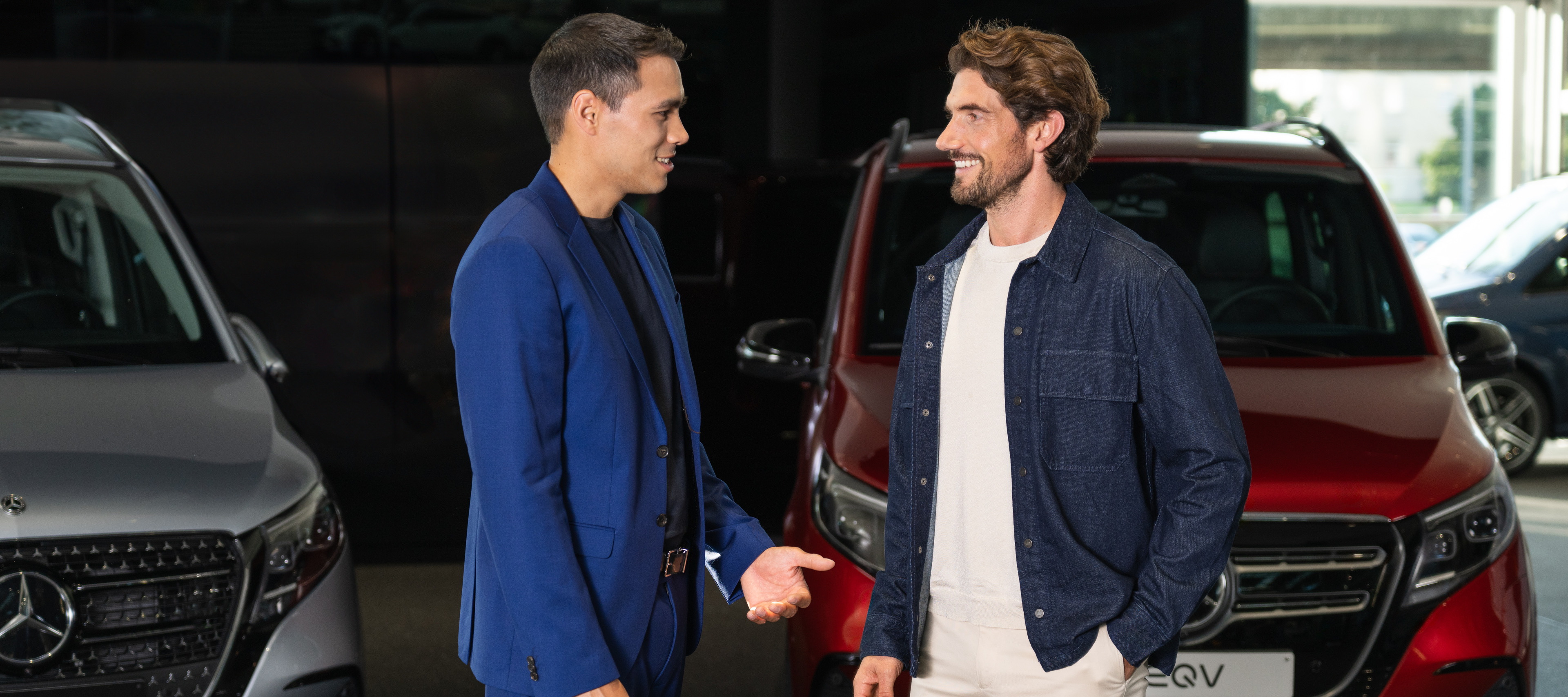 Operating Lease Two people talking to each other in front of two Mecedes-Benz vans.
