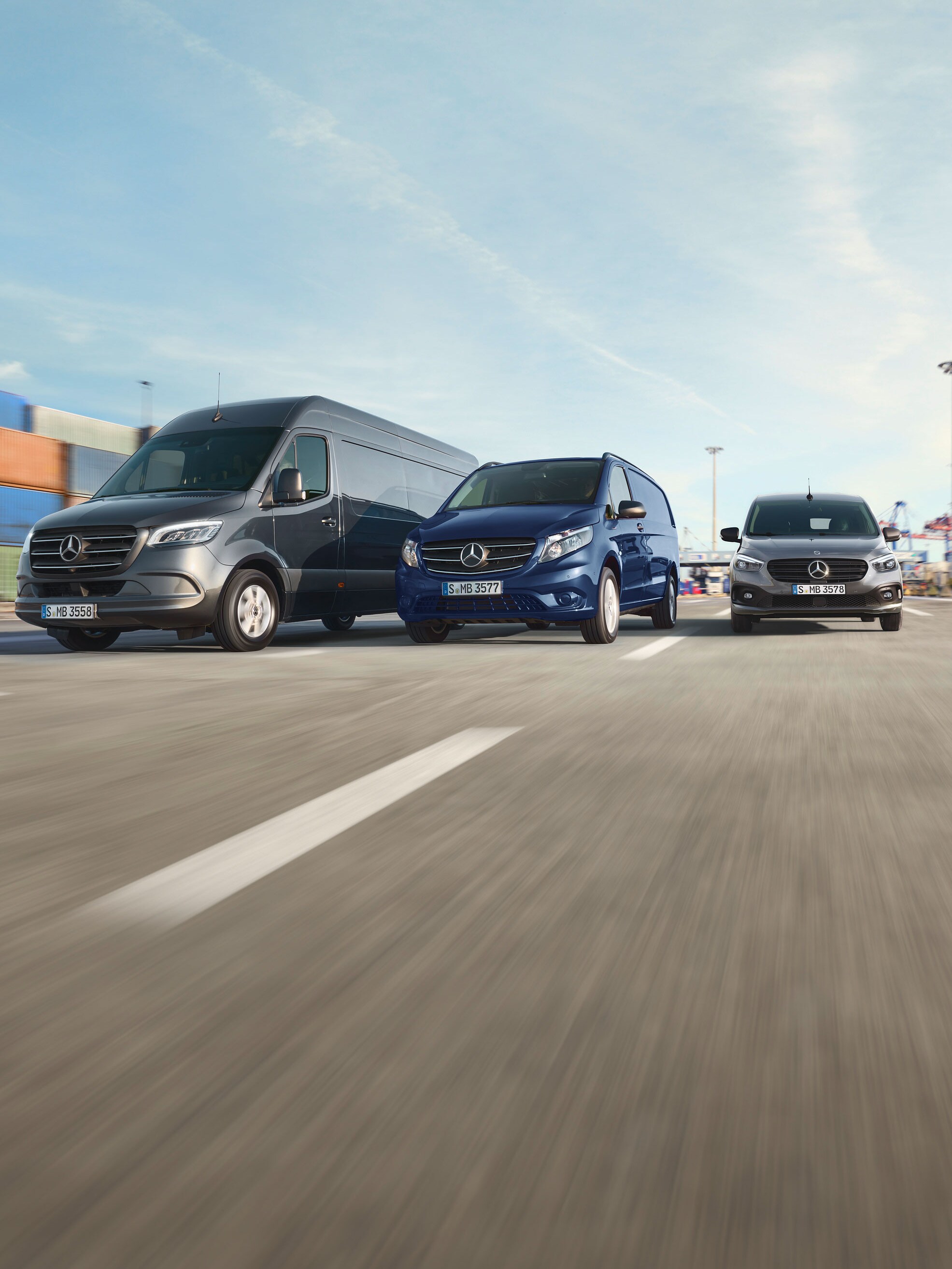 A woman, standing in front of her Mercedes and looking in a good mood.