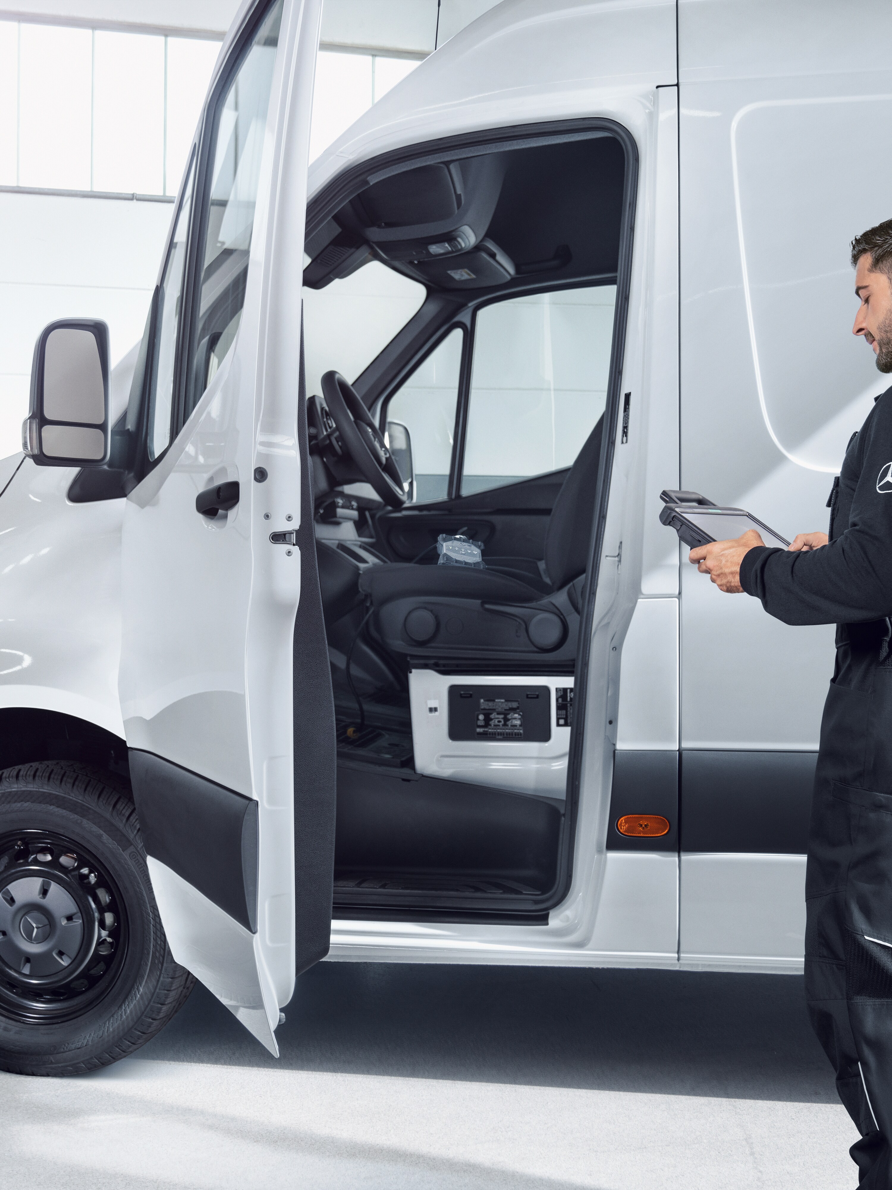 A Mercedes-Benz eSprinter van being serviced by a technician.