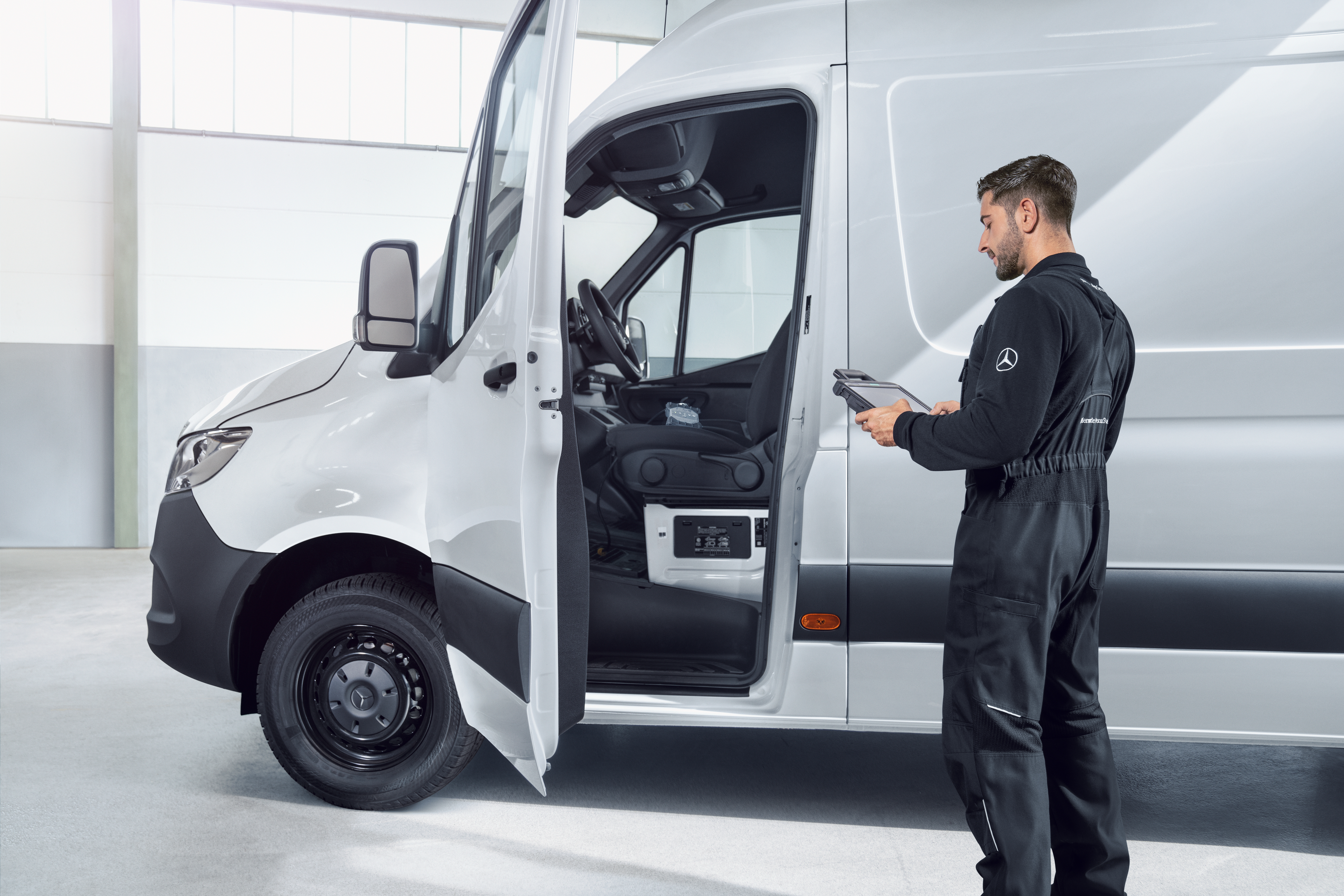 ISP Person standing beside an open Mercedes-Benz van while using a handheld device