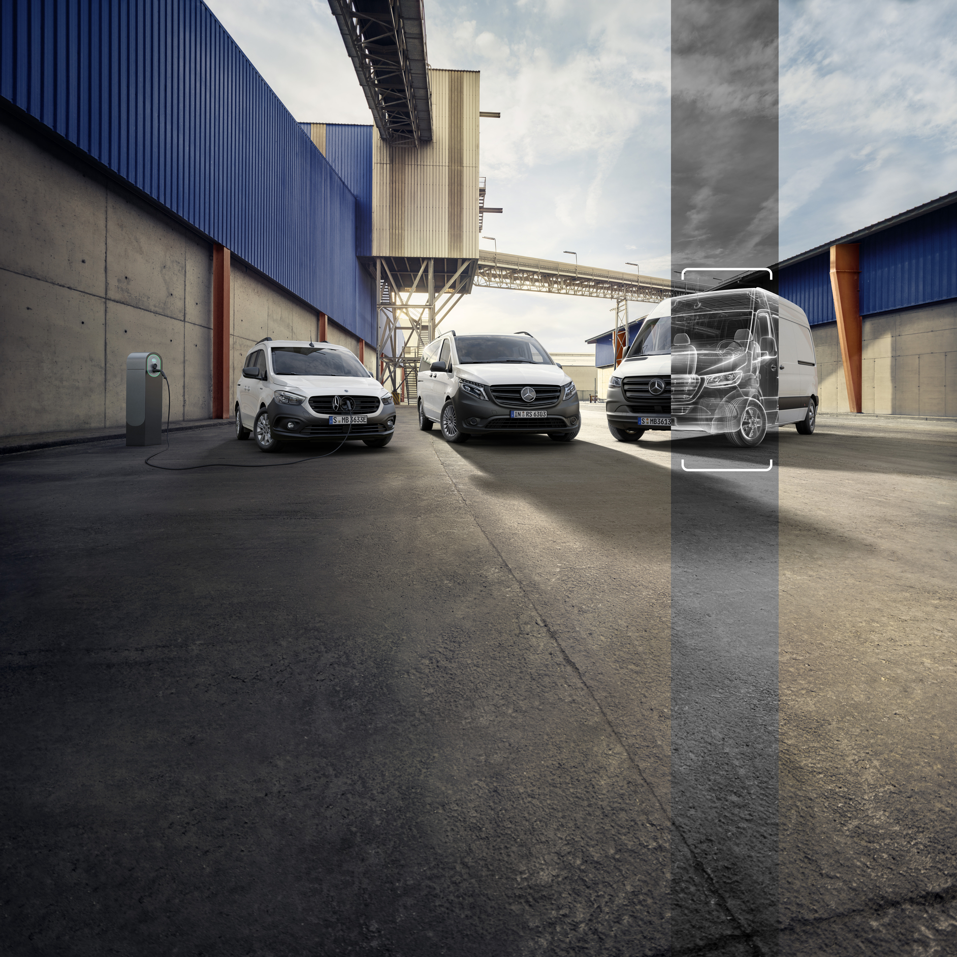 Three Vans in an Industrial Setting | Mercedes-Benz Vans Three white Mercedes-Benz vans in an industrial setting background. One is charging, and the third is shown as a wireframe overlay.