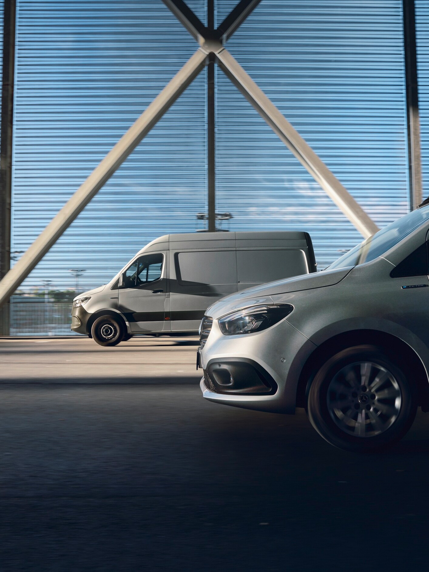 Mercedes-Benz eCitan electric van charging at a station, partially shown in x-ray view revealing interior parts.