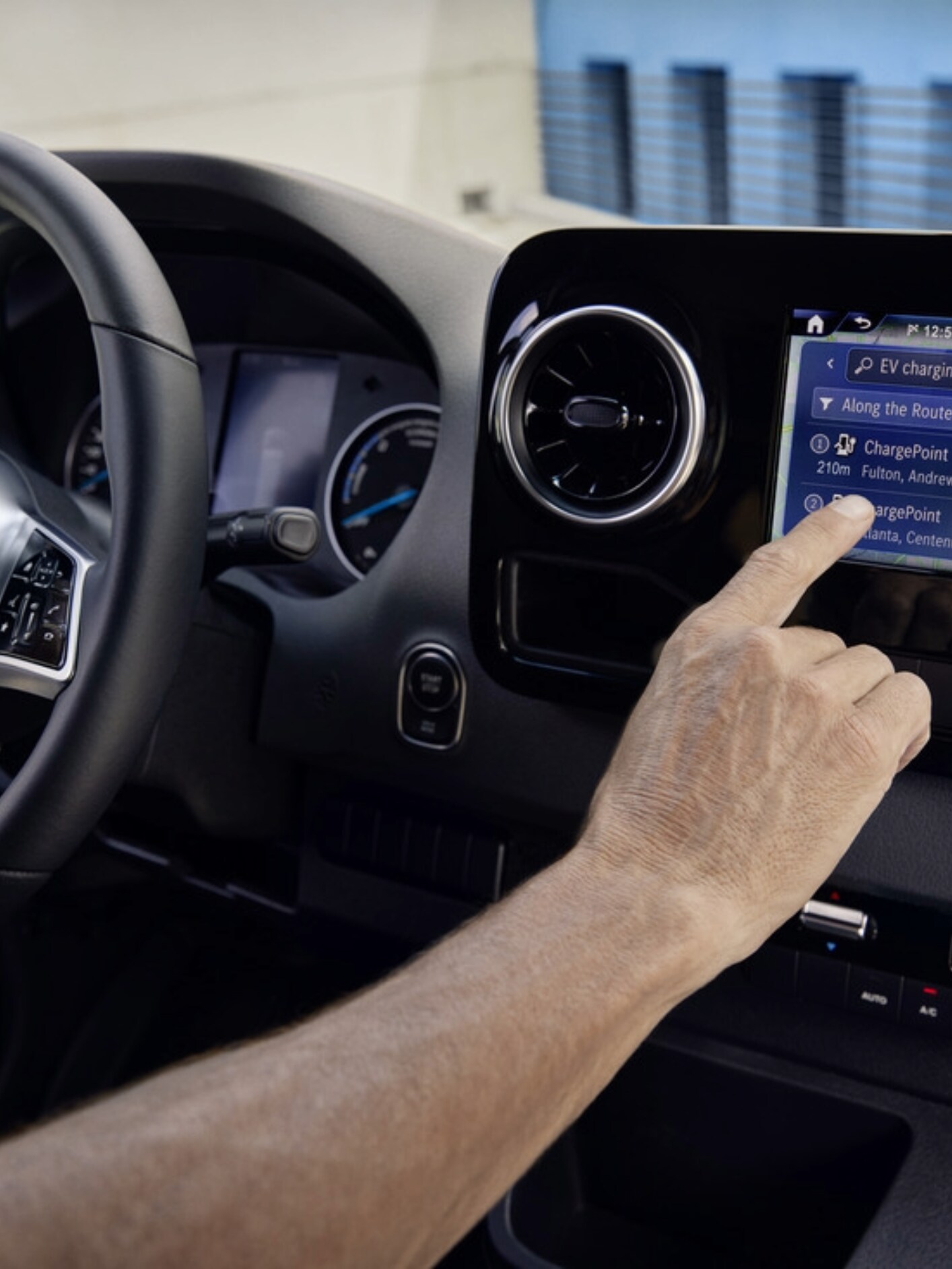 A person using the MBUX infotainment system in a Mercedes-Benz electric van.