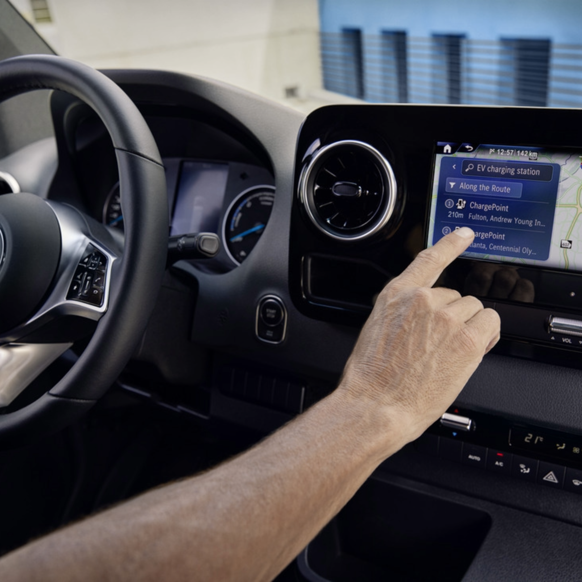 MBUX Infotainment System Screen on Electric Van | Mercedes-Benz Vans A person using the MBUX infotainment system in a Mercedes-Benz electric van.