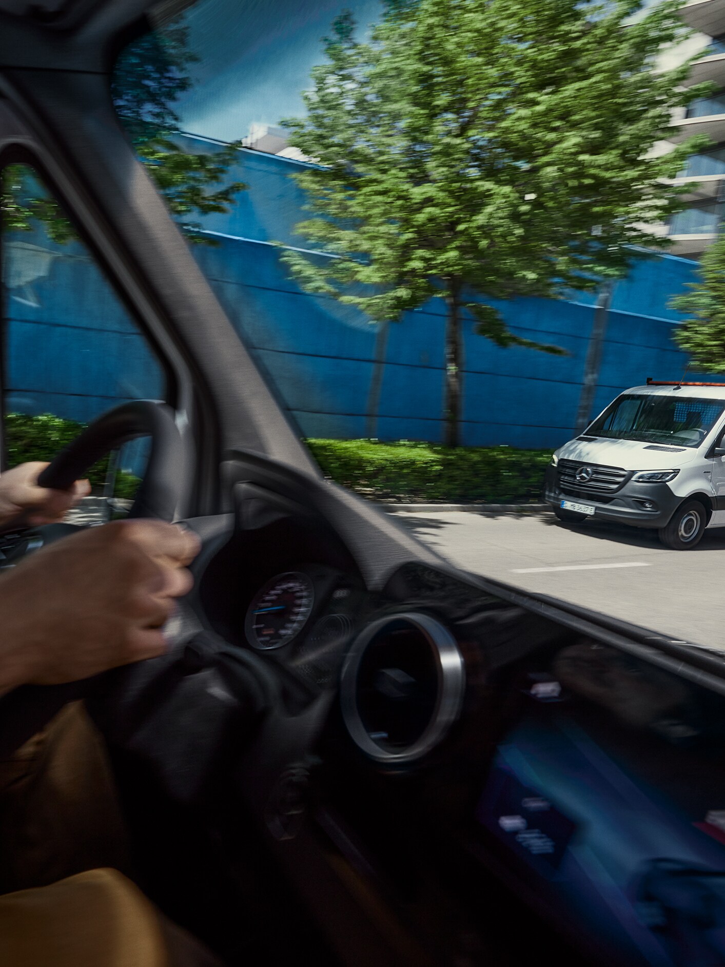 The interior of a Mercedes-Benz van from the driver's perspective with a Sprinter Chassis Cab parked outside.