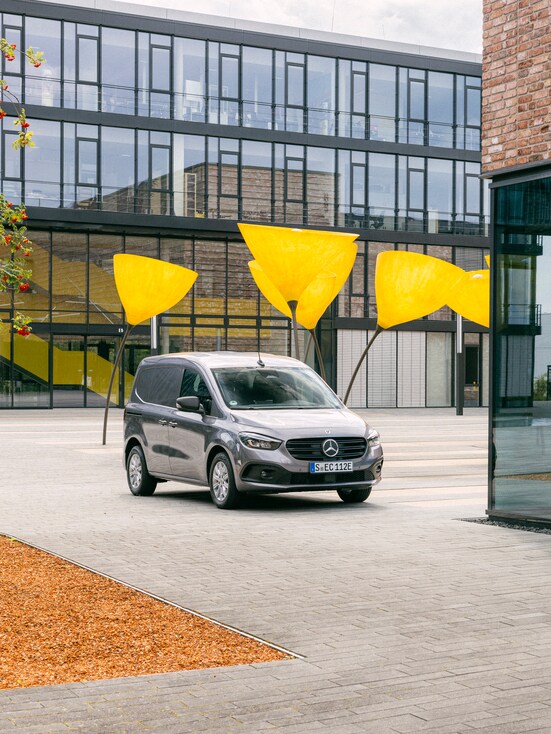 A grey Mercedes-Benz Citan parked in front of a building.