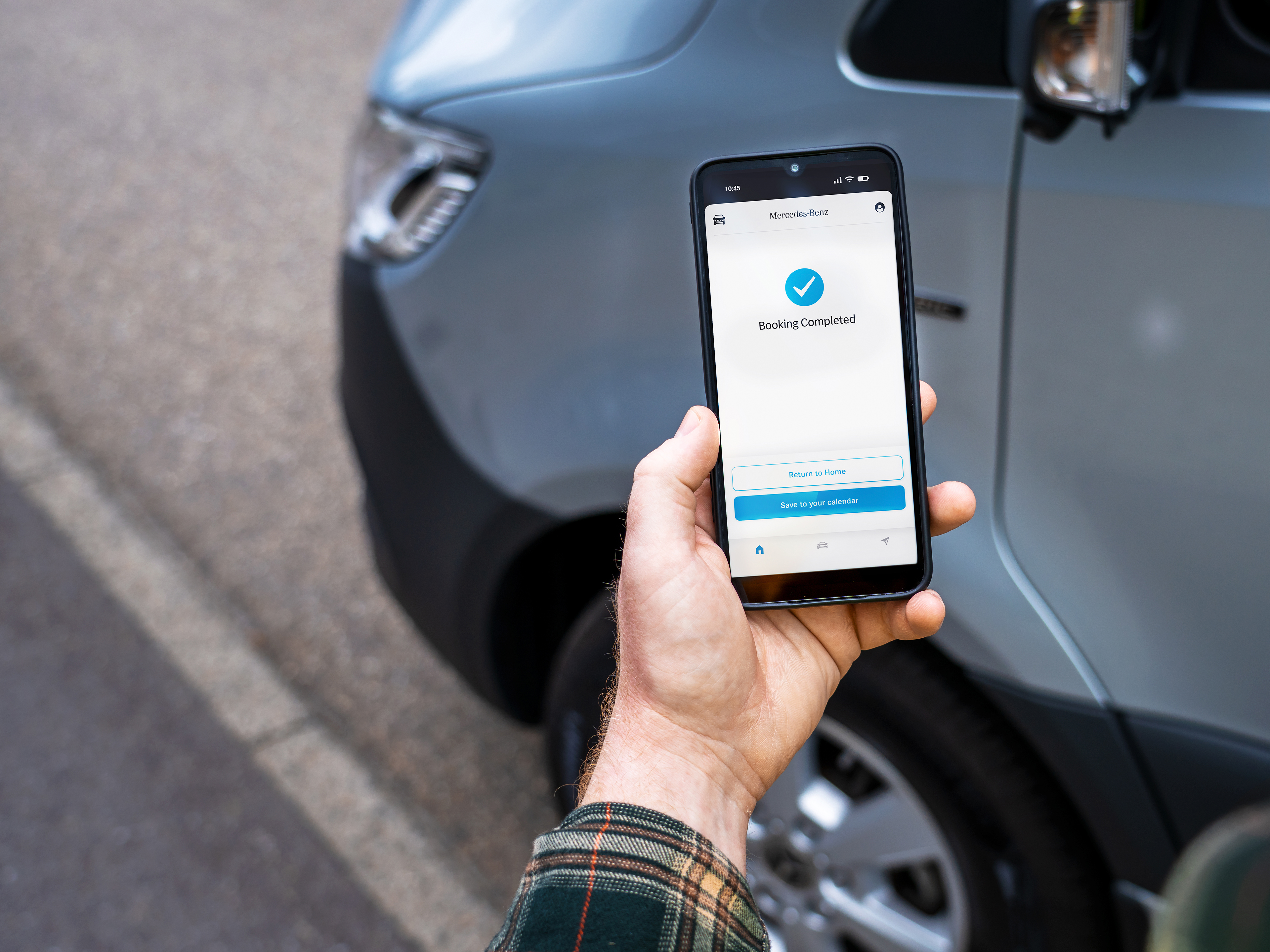 Booking completed confirmation on smartphone | Mercedes-Benz Vans A hand holding a smartphone displaying a 'Booking Completed' confirmation screen.
