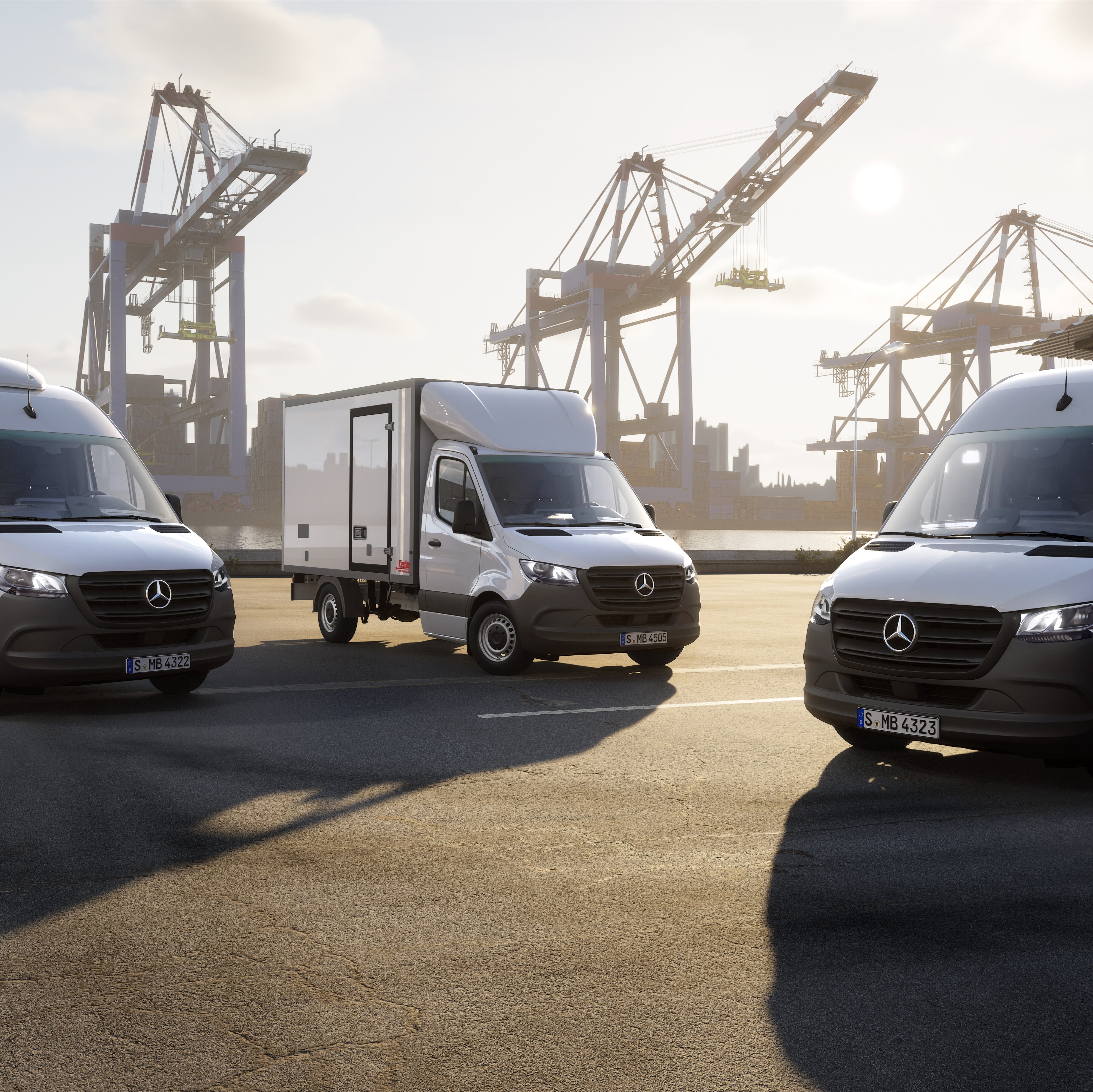 A low-angle shot of three white Mercedes-Benz Sprinter vans parked in a port area.