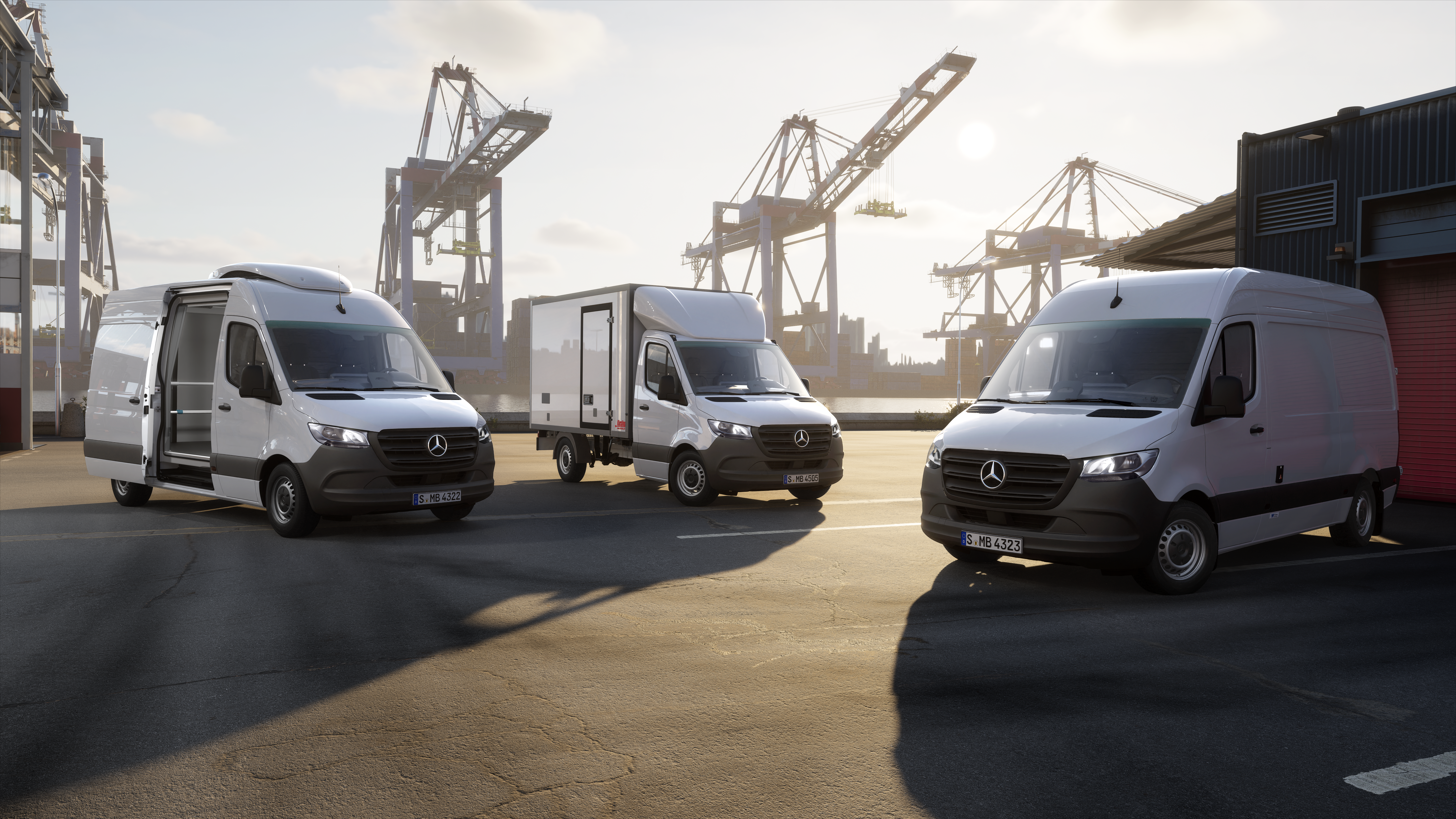Three Mercedes-Benz Sprinter Vans | Mercedes-Benz Vans A low-angle shot of three white Mercedes-Benz Sprinter vans parked in a port area.