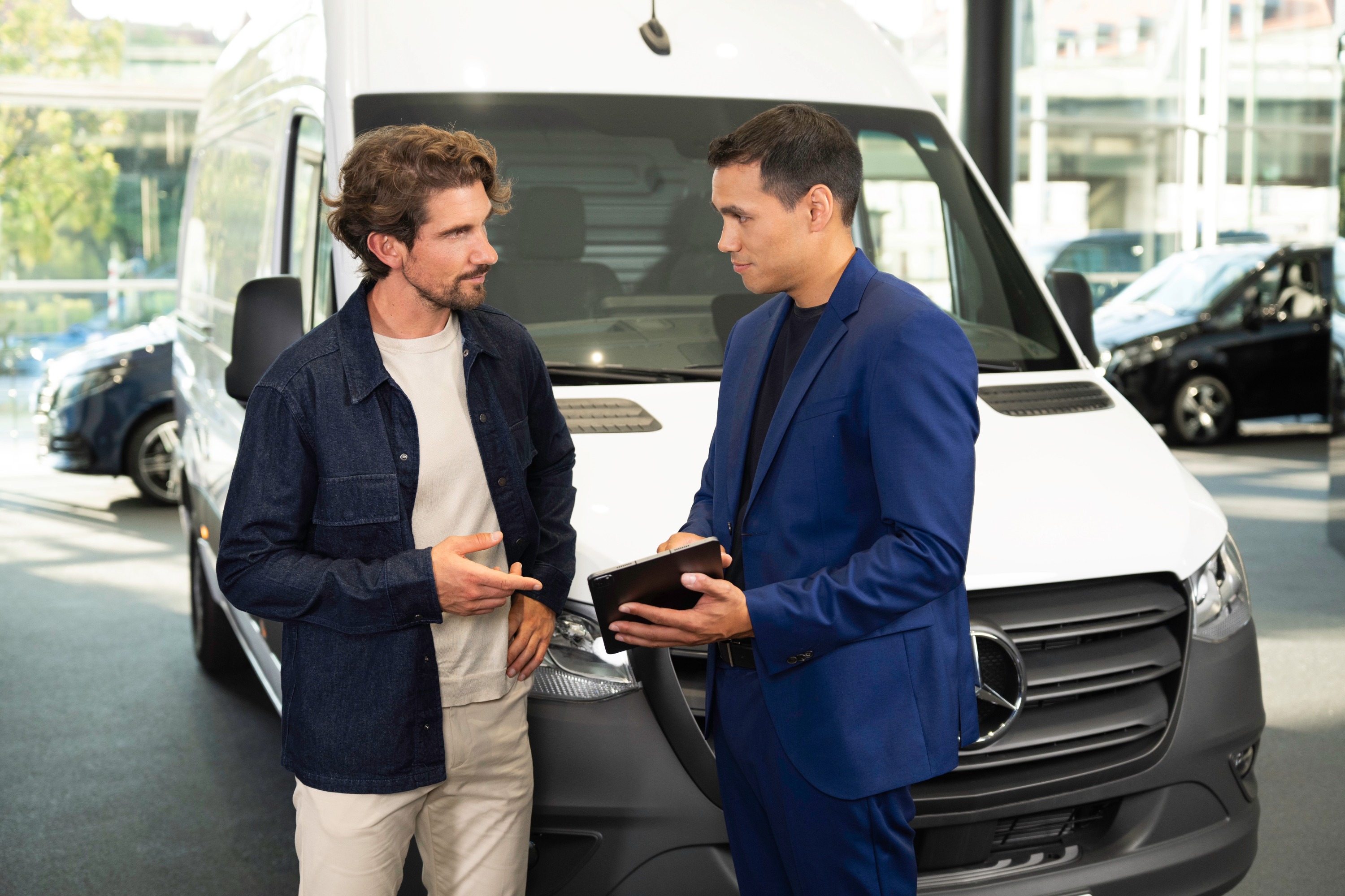 Finance your fleet | Mercedes-Benz Vans Two men looking at a tablet device in front of a Mercedes-Benz Sprinter Panel Van.