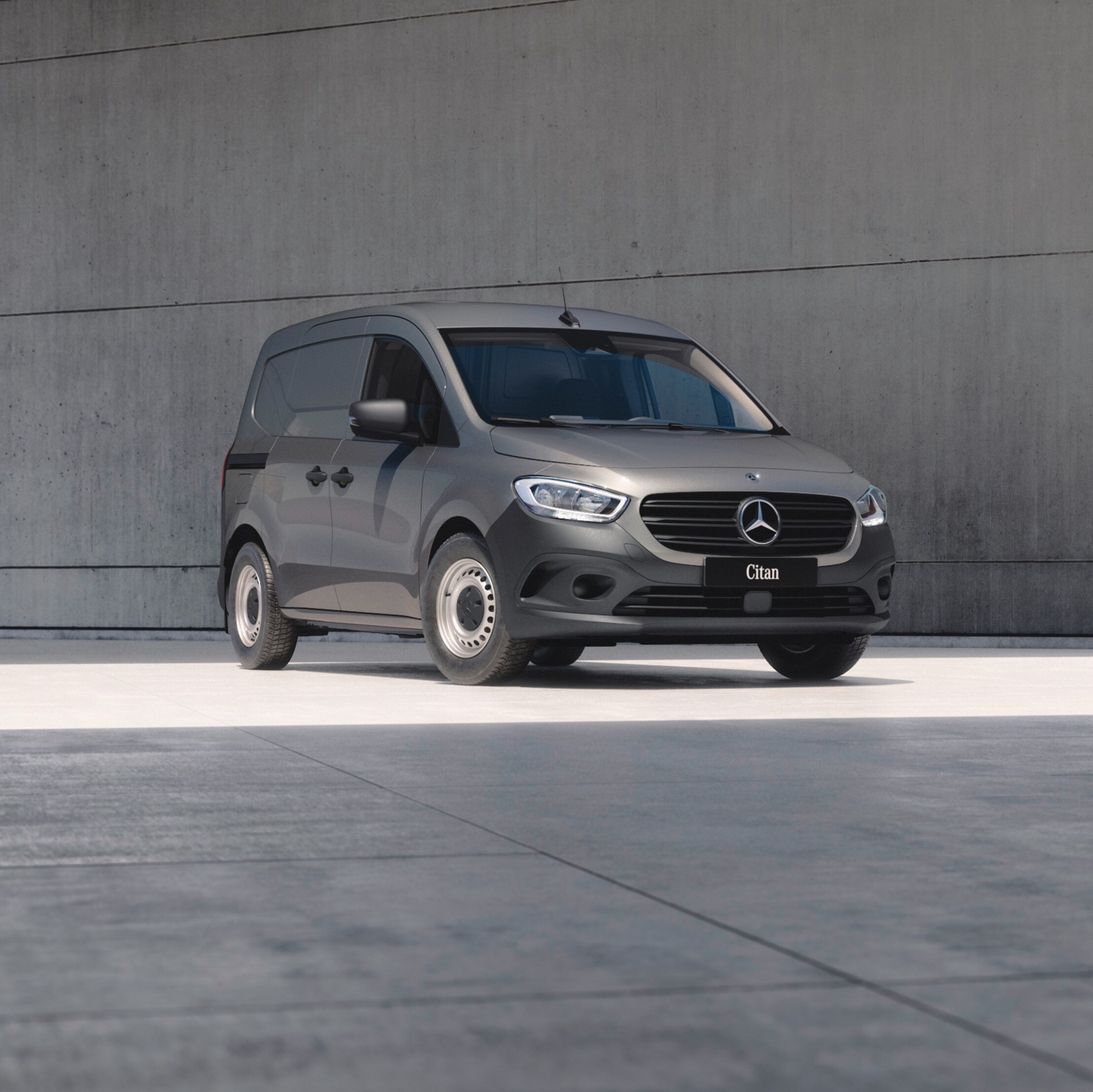 Birdseye view of three Mercedes-Benz panel vans – a grey Citan, a white Vito and a dark Blue Sprinter – under a bridge in an urban setting.