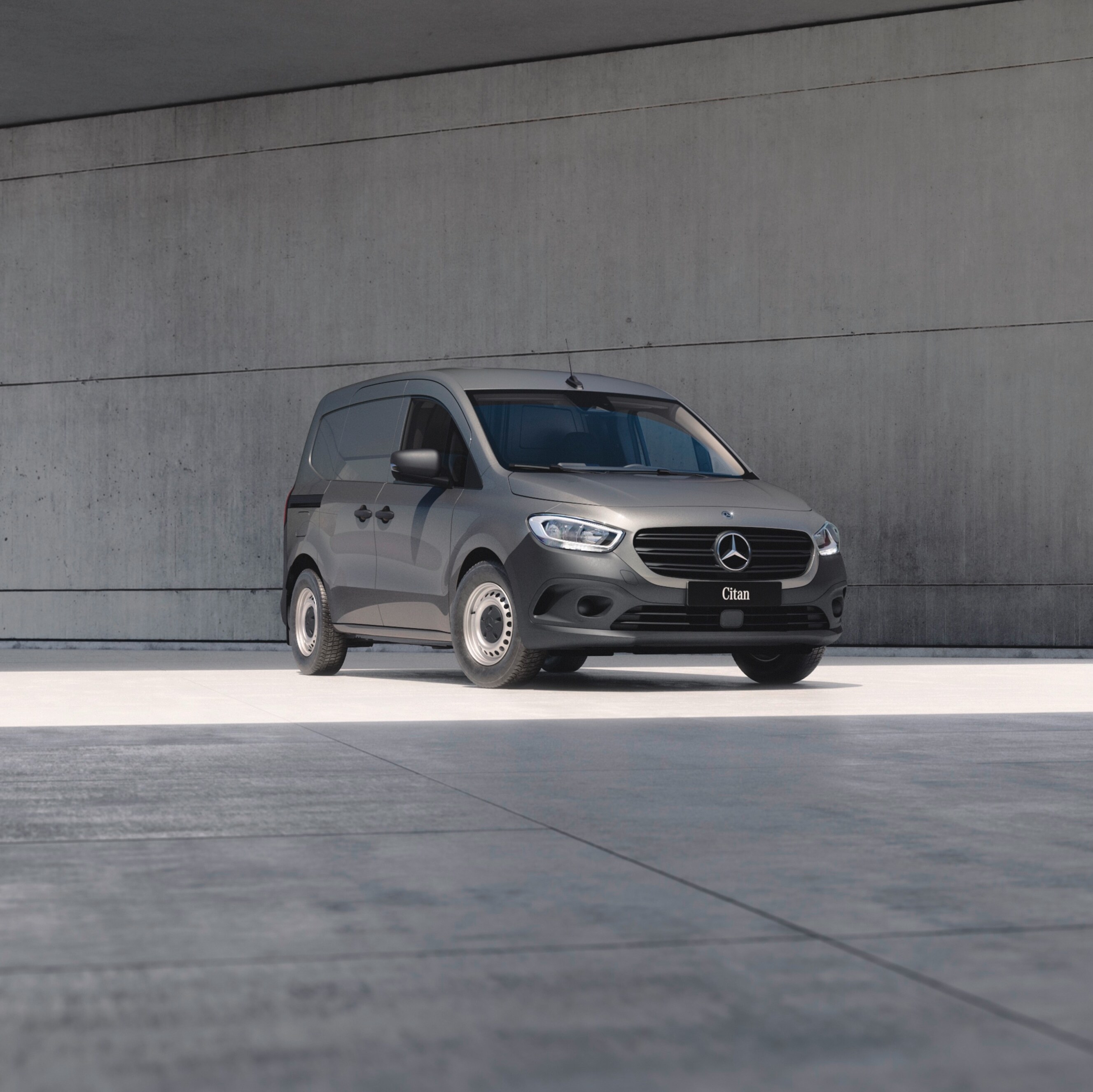 Birdseye view of three Mercedes-Benz panel vans – a grey Citan, a white Vito and a dark Blue Sprinter – under a bridge in an urban setting.