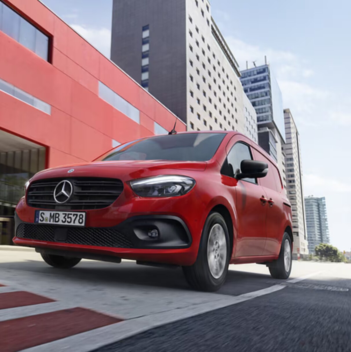 The Mercedes-Benz eCitan in its tourer and panel van versions standing in front of a site of industrial aspect.
