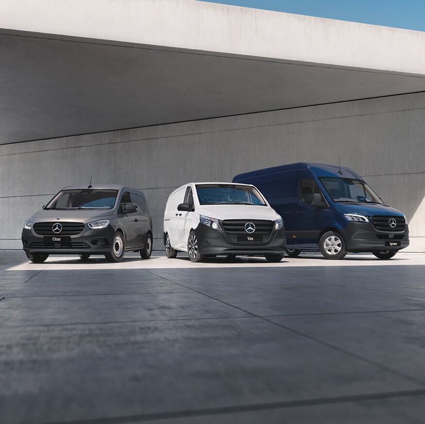 Three Mercedes-Benz panel vans – a grey Sprinter, a blue Vito, and a yellow Citan – positioned on a rooftop with a cityscape backdrop.