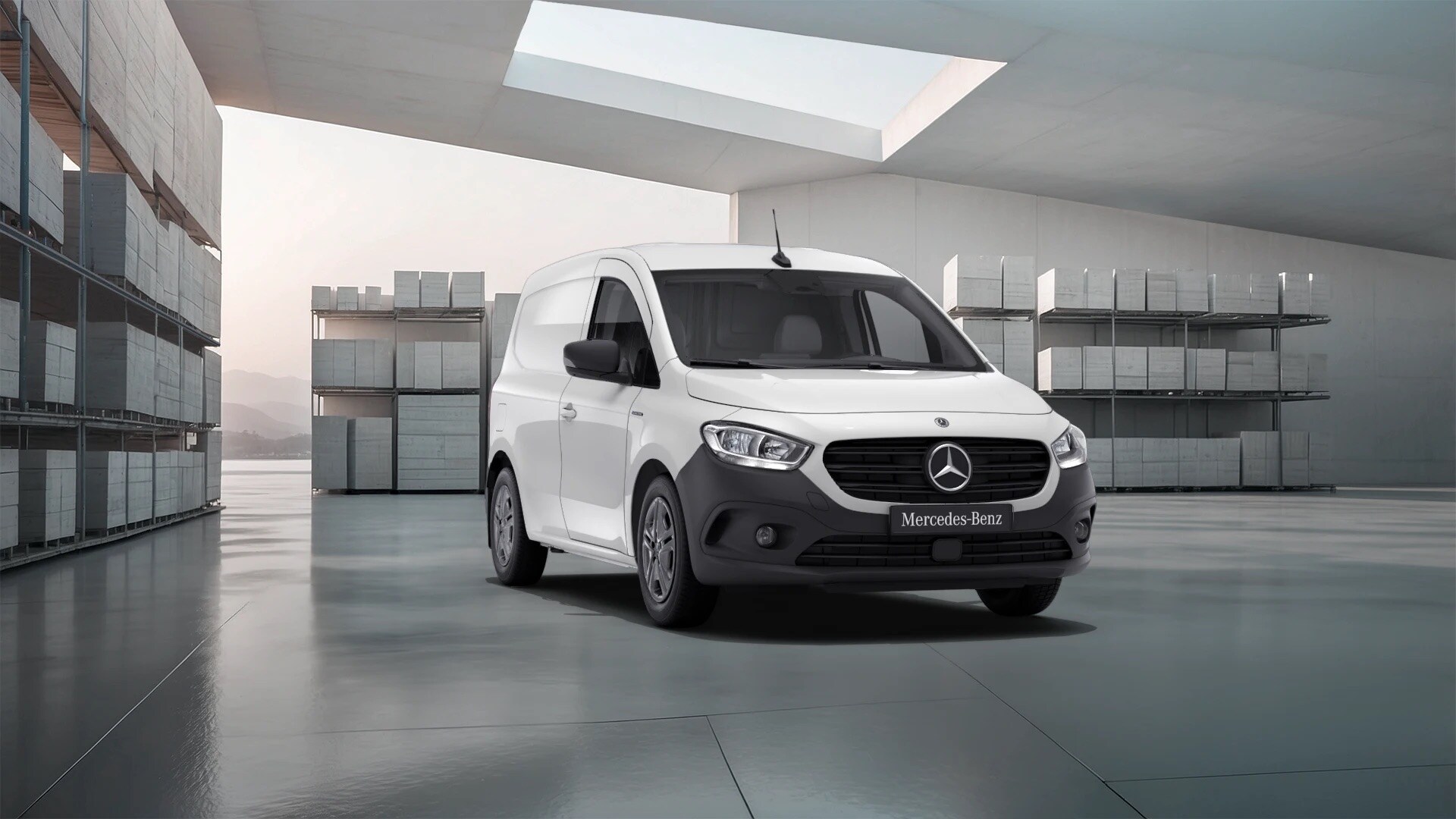 White Mercedes-Benz eCitan Panel Van parked in a bright industrial warehouse.