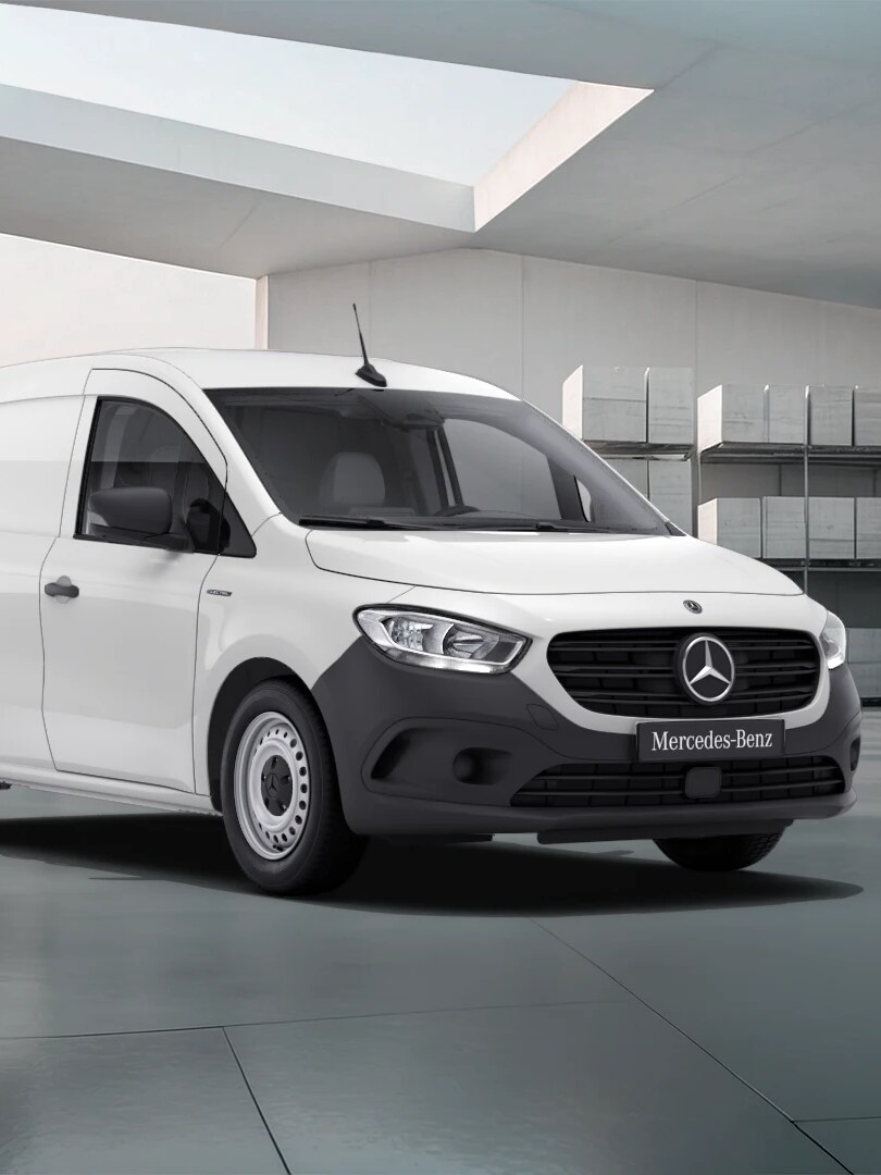 White Mercedes-Benz eCitan Panel Van parked by modern concrete structure.