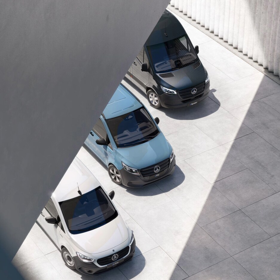 Birdseye view of three Mercedes-Benz panel vans – a grey Citan, a white Vito and a dark Blue Sprinter – under a bridge in an urban setting.