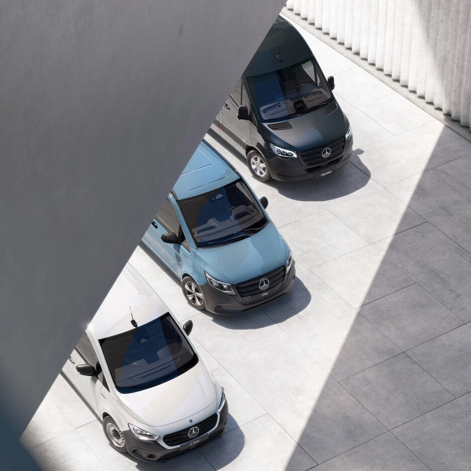 Birdseye view of three Mercedes-Benz panel vans – a grey Citan, a white Vito and a dark Blue Sprinter – under a bridge in an urban setting.
