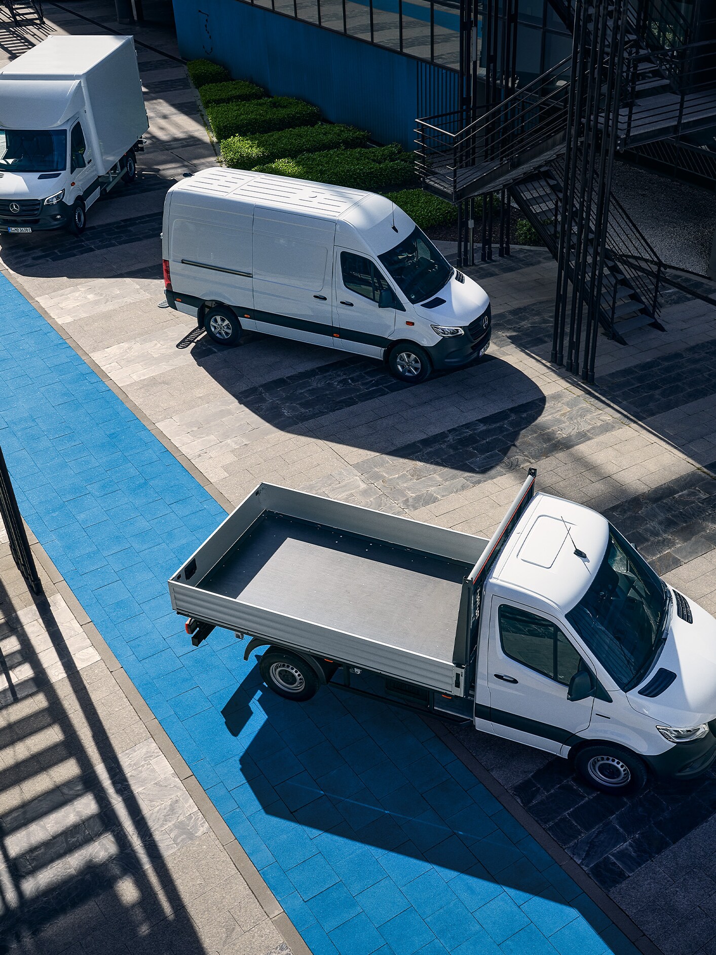 A group of Mercedes-Benz Sprinter vans parked on a street, featuring a panel van, a Luton box van and a chassis cab.
