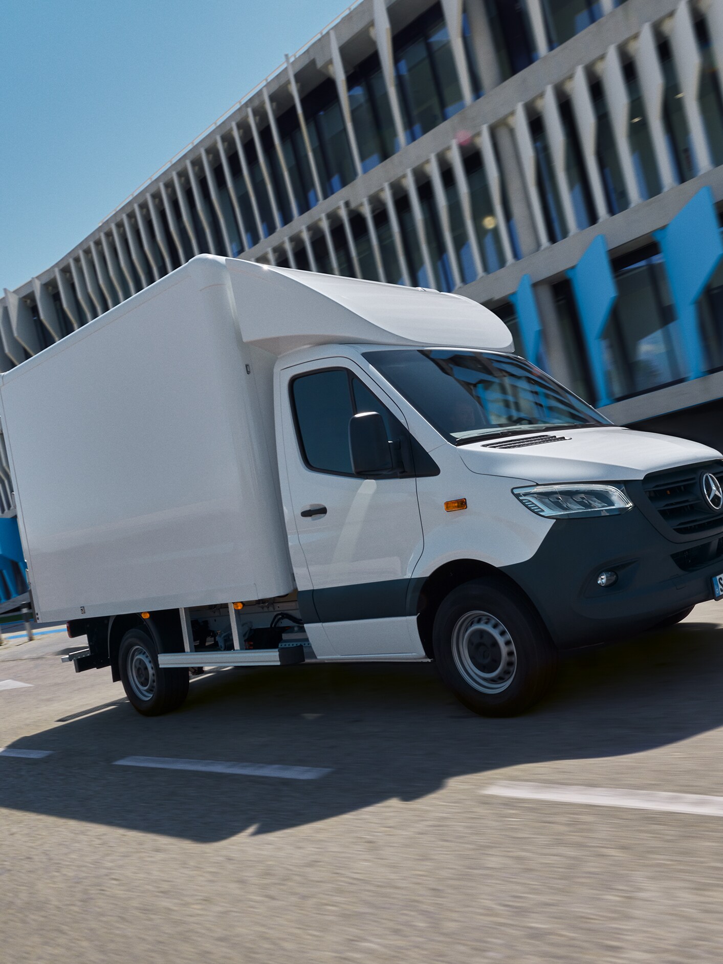 A white Mercedes-Benz Sprinter Luton Box van on the street.