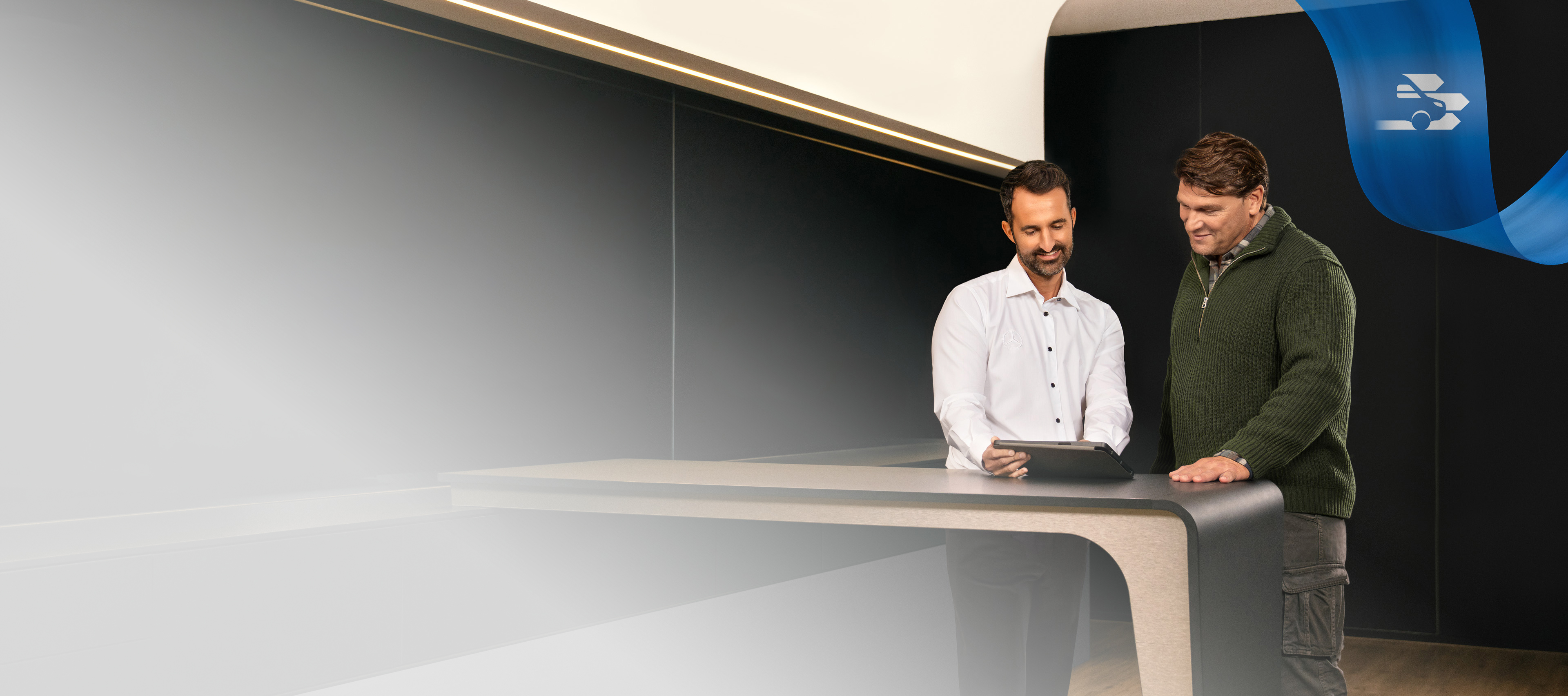 Mercedes-Benz | Convenience | Authorised Repairer Two Men standing in a Mercedes-Benz Authorised Repairer office, discussing something seen on a Tablet