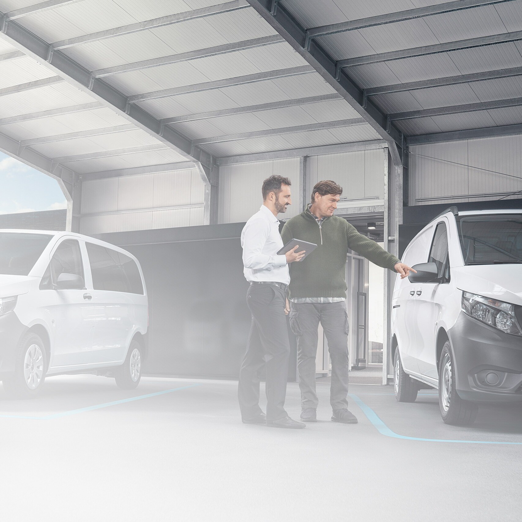 Mercedes-Benz customer support agent with client in a service partner location in front of a van.