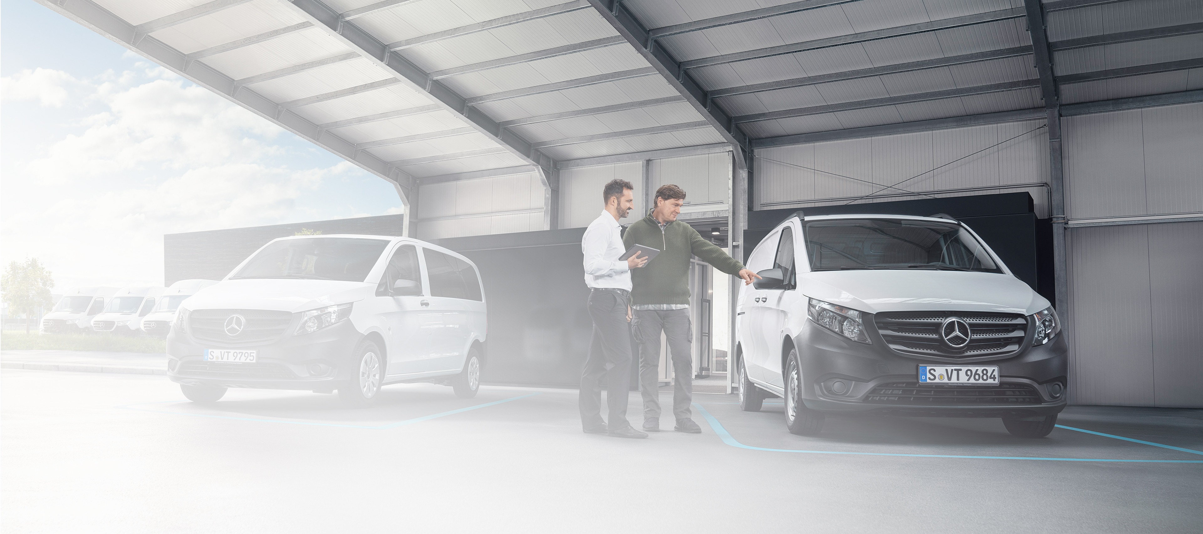 Mercedes-Benz | Recall Mercedes-Benz customer support agent with client in a service partner location in front of a van.