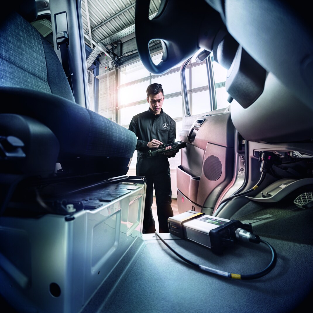 Mercedes-Benz van being serviced by a technician in a workshop