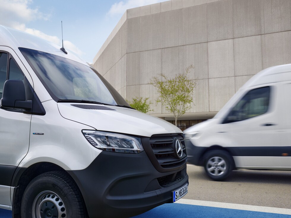 Two white Mercedes-Benz Sprinter vans on the move.